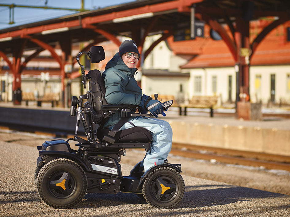 Young man in X850 power wheelchair with family